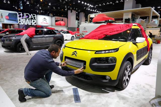 An employee prepares a Citroen C4 Cactus car which is displayed at French carmaker Citroen showcase for the Paris Mondial de l'Automobile