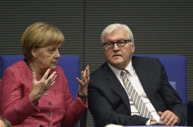 Canciller alemana, Angela Merkel (i), conversa con el ministro alemán de Exteriores, Frank-Walter Steinmeier (d), durante una sesión extraordinaria del parlamento alemán en Berlín. EFE