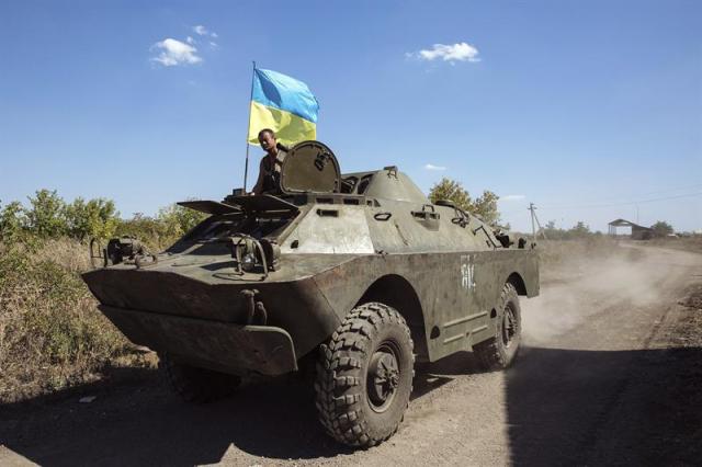 Un soldado ucraniano monta guardia sentado sobre un carro blindado en la región de Donetsk (Ucrania). EFE