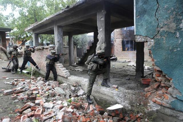 Ejército indio disparan hacia una casa en ruinas en la que se esconden rebeldes cachemiríes durante los enfrentamientos registrados en Rajpora. EFE
