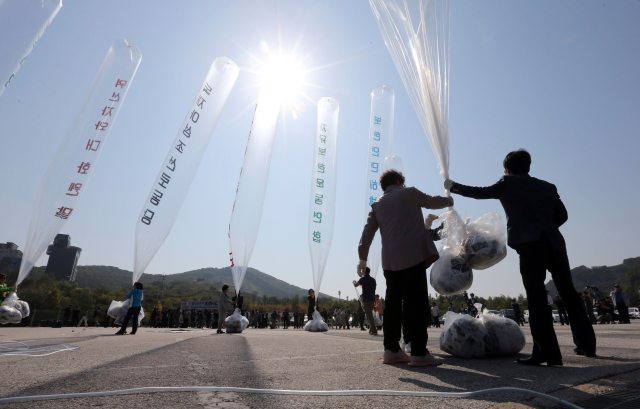 Los ex desertores norcoreanos sostienen un globo que contiene folletos anti-Corea del Norte, mientras se preparan para liberarlos hacia el norte, cerca de la zona desmilitarizada en Paju, 10 de octubre 2014 (Reuters)