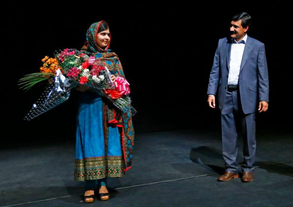 Pakistani schoolgirl Malala Yousafzai, the joint winner of the Nobel Peace Prize, stands with her father Ziauddin after speaking at Birmingham library in Birmingham