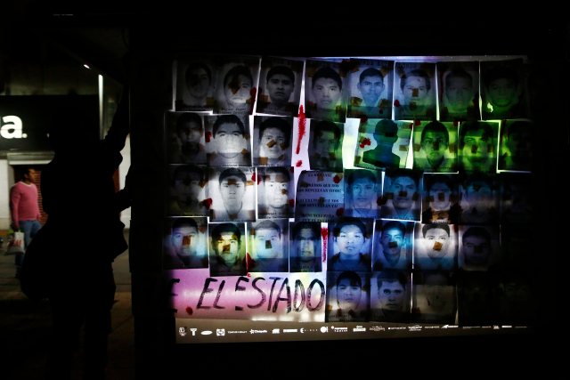 Protesters hold a banner with the photographs of 43 trainee teachers during a march denouncing the apparent massacre of the students in Mexico City
