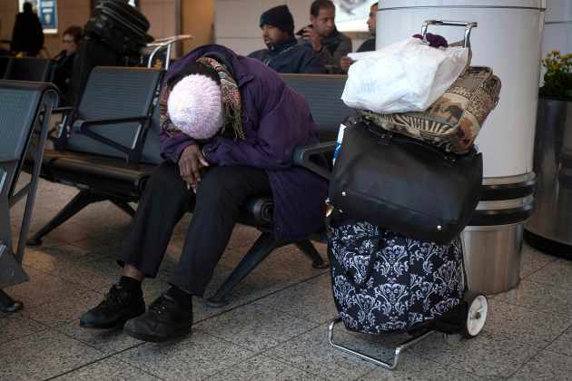 A woman sleeps at LaGuardia airport on the day before Thanksgiving in New York