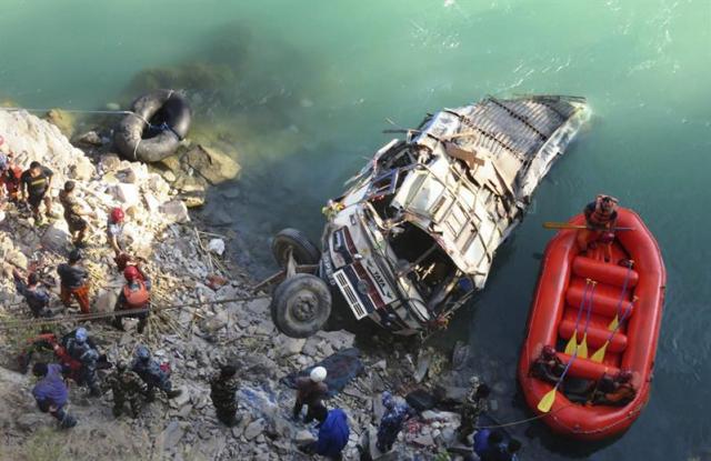Grupo de los servicios de rescate mientras proceden a la búsqueda de las víctimas de un accidente de un autobús que cayó al río Bheri en el distrito de Jajarkot, al oeste del Nepal. (Foto  EFE / BHIM BSHADUR)