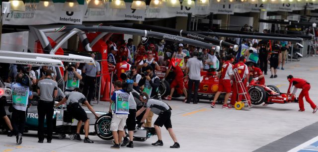 Mercedes Formula One driver Hamilton of Britain and Ferrari Formula One driver Alonso of Spain has their cars pushed to the box during the first practice session of the Brazilian Grand Prix in Sao Paulo