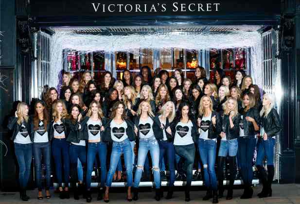 Models pose for a group photograph outside the Victoria's Secret shop on New Bond Street in central London