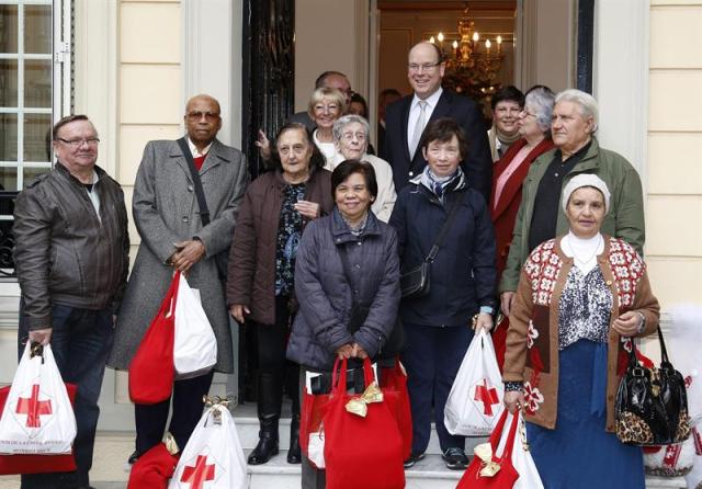 El príncipe Alberto II (arriba, c) de Mónaco, posa junto a un grupo de residentes monegascos durante la cita anual benéfica celebrada en la sede de la Cruz Roja en Mónaco, hoy, 16 de diciembre de 2014. (foto EFE/SEBASTIEN NOGIER)