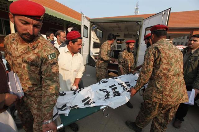 Soldados paquistaníes retiran los cadáveres de varias víctimas del ataque talibán contra un colegio gestionado por el Ejército en Peshawar (foto EFE/Arshad Arbab)