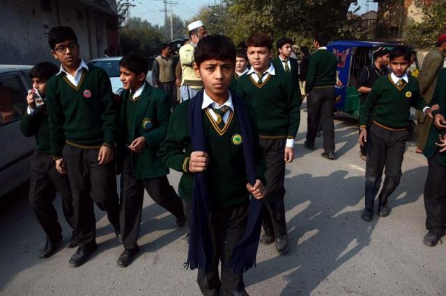 Varios alumnos rescatados por las Fuerzas de Seguridad salen del centro tras el ataque talibán contra un colegio gestionado por el Ejército en Peshawar (foto EFE/Bilawal Arbab)