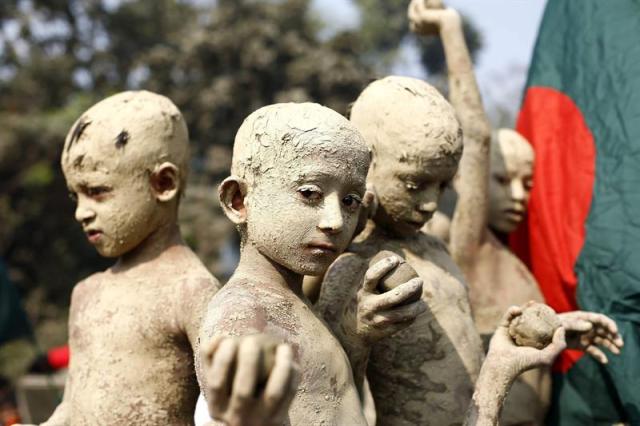Niños cubiertos de barro asisten a un desfile con motivo del Día de la Victoria en Gazipur (foto EFE/Abir Abdullah)