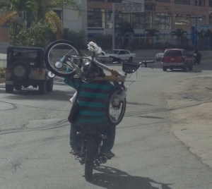 Así llevan una bicicleta en una moto (fotos)
