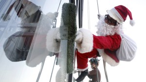 No solo chimeneas, Santa también llega a los rascacielos por rapel (Fotos)