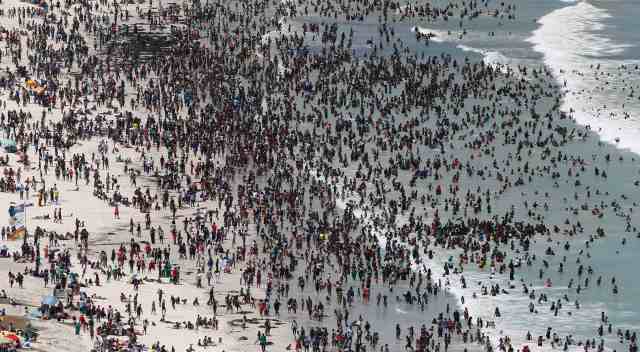 Thousands of people flock to celebrate New Year's Day on Cape Town's Muizenberg beach