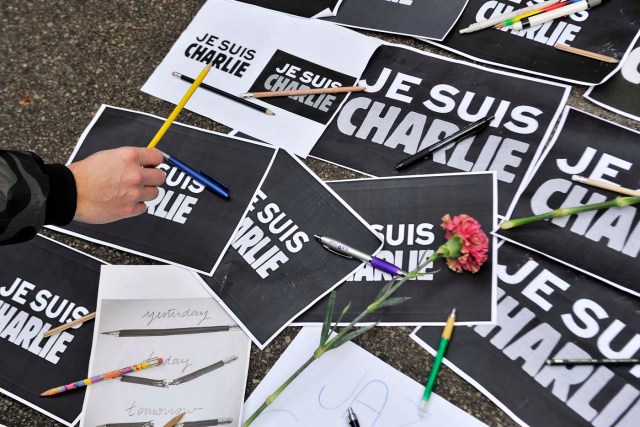 A man puts a pencil on placards reading "I am Charlie" during a minute of silence for the victims of Wednesday's shooting at the Paris offices of weekly newspaper Charlie Hebdo in Ljubljana