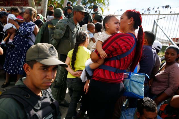 National Guards control access as people line up outside a state-run Bicentenario supermarket in Caracas