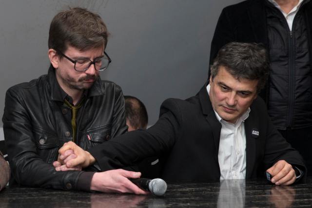 Satirical French magazine Charlie Hebdo columnist Pelloux comforts cartoonist Luz as they attend a news conference at the French newspaper Liberation offices