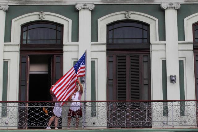 Hotel employees hoist a U.S. flag prior to the arrival of US Senator Patrick Leahy in downtown Havana