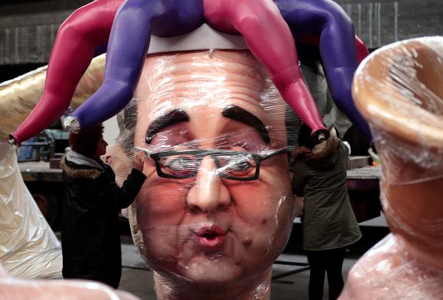 Workers put the final touches on a giant figure of French President Hollande during preparations for the carnival parade in Nice