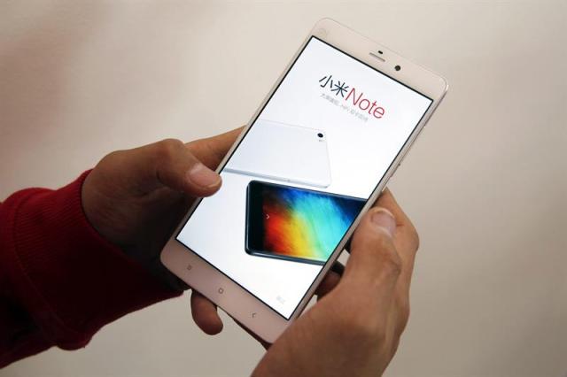 (CHINA) 12/02/2015.- Un usuario revisa un teléfono móvil Xiaomi en un centro de exposición de productos de Xiaomi en Pekín (China) hoy, jueves 12 de febrero de 2015. La compañía es el tercer productor de teléfonos más importante del mundo después de Apple y Samsung. El valor estimado de la compañía ronda los 50.000 millones de dólares. EFE/Wu Hong