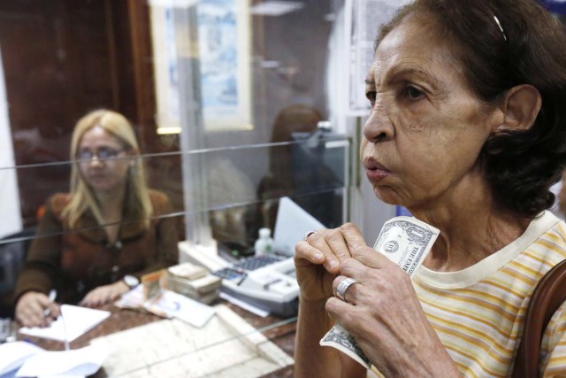  Una mujer venezolana porta billetes de un dólar en Caracas. REUTERS 