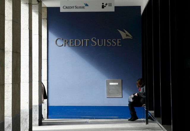 A woman sits outside a branch of the Credit Suisse bank in Bern