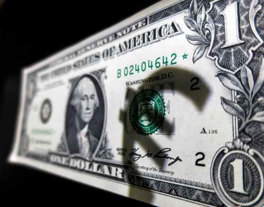 En la imagen, la sombra del euro sobre un billete de dólar en Madrid