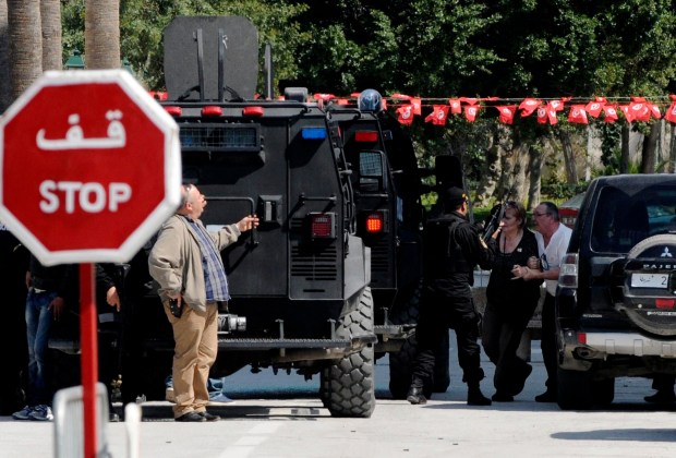 A tourist is helped to a vehicle after an attack by gunmen on Tunisia's national museum in Tunis