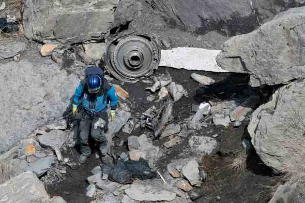 A French rescue worker inspects the debris from the Germanwings Airbus A320 at the site of the crash, near Seyne-les-Alpes, French Alps