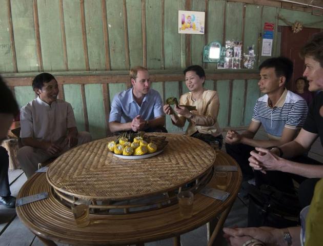 El príncipe Guillermo (2ºizda), duque de Cambrigde, toma arroz envuelto en hojas de plátano durante su visita a Mengman (China) hoy, miércoles 4 de marzo de 2015. EFE/John Stillwell