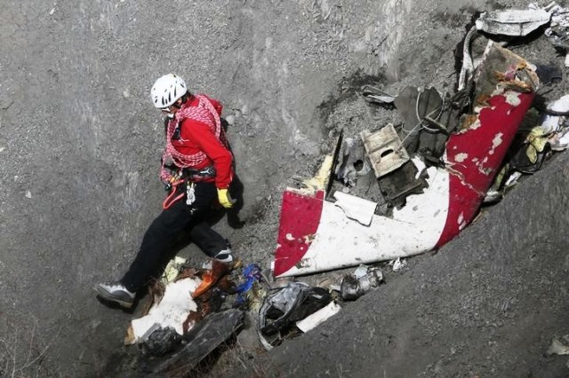 Foto: Un socorrista revisa restos del avión Airbus A320 de Germanwings estrellado en los Alpes franceses / Reuters
