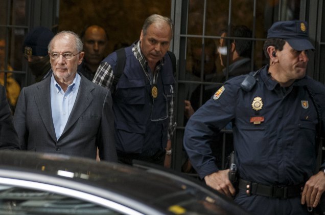 Rato, former People's Party minister and former managing director of the International Monetary Fund, is lead by police as they leave his residence after an inspection in Madrid