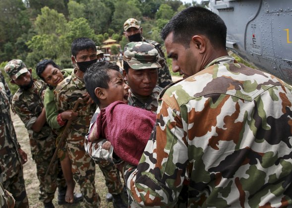 Injured boy cries in pain as he is carried by Nepal Army personnel to a helicopter following Saturday's earthquake in Sindhupalchowk