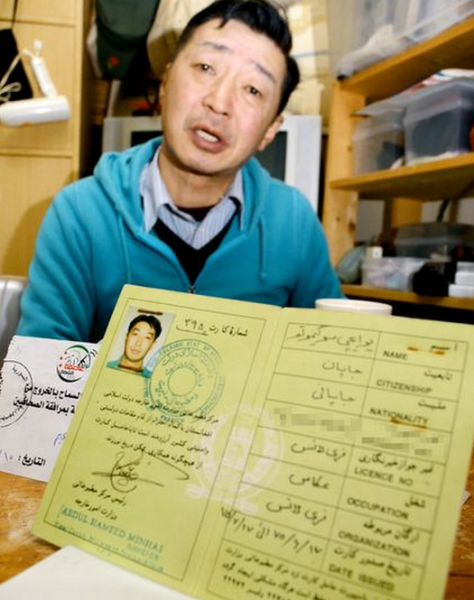 Foto: Yuichi Sugimoto muestra un certificado de notificación que recibió por una visita pasadas al extranjero / asahi.com