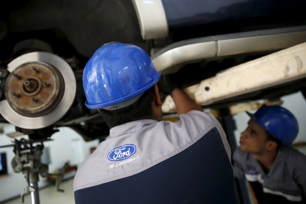 The corporate logo of Ford is seen on the uniform of a mechanic at a Ford branch in Caracas