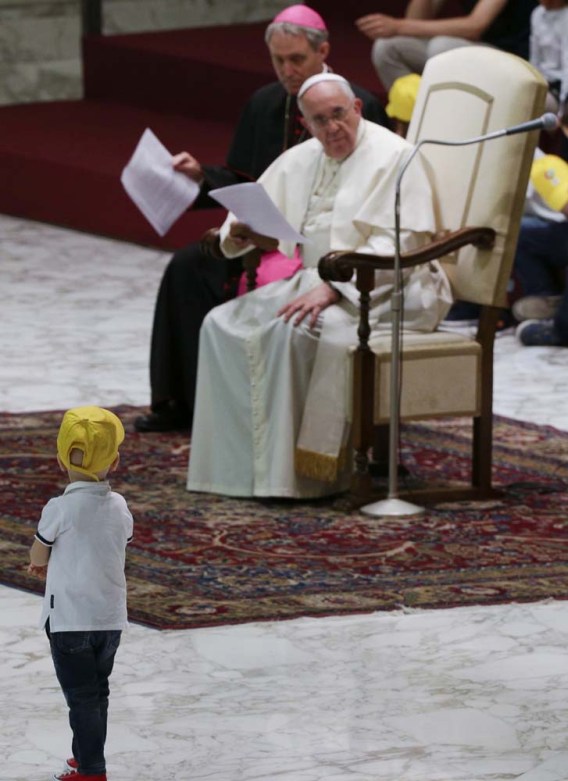 A boy from the "Fabbrica della Pace" group approaches Pope Francis as he holds an audience at the Vatican