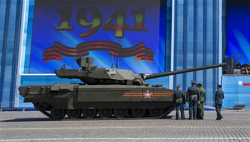Oficiales del ejército ruso hablan sobre un tanque con un miembro de la tripulación del T-14 Armata en la plaza Roja de Moscú durante los preparativos para el ensayo general del desfile militar del Día de la Victoria que se celebrará en la plaza moscovita el 9 de mayo para celebrar los 70 años de la victoria del país en la IIGM, en Moscú, Rusia, el 7 de mayo de 2015. (Foto AP/Alexander Zemlianichenko)