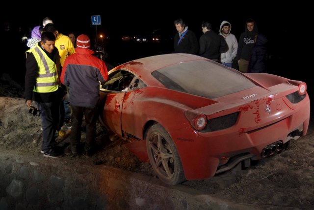 A red Ferrari belonging to Chile's player Arturo Vidal, is seen after a car crash on a highway, south of Santiago