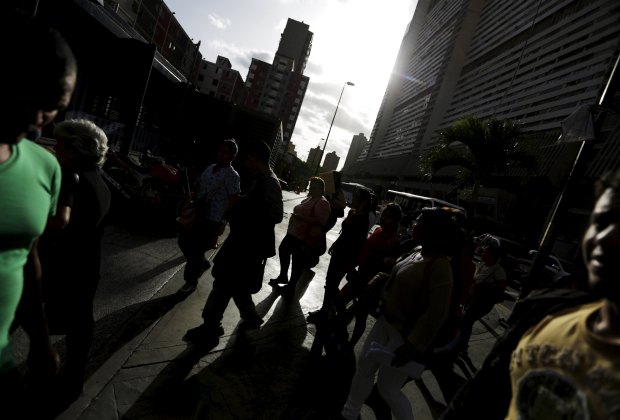 People walk in sunset in streets of Caracas