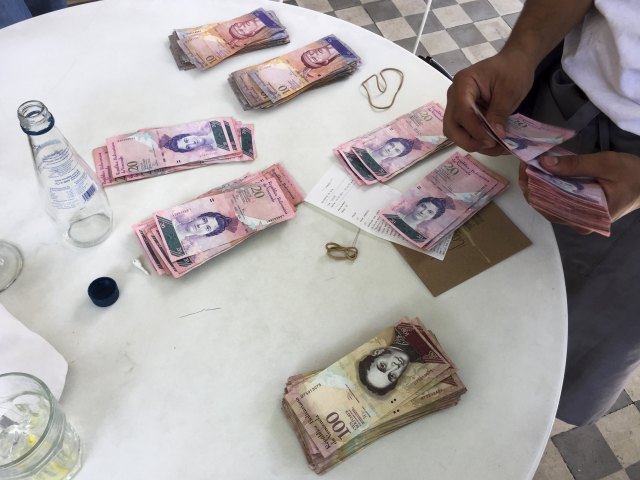 A waiter counts Venezuelan bolivar notes, corresponding to the bill for a lunch of 4 people, at a restaurant in Caracas July 14, 2015. The bill was 13,126 bolivars, equivalent to 2,067 U.S. dollars at the official exchange rate of 6.3 bolivars per dollar or approximately 20 U.S. dollars according to the black market exchange rate. A debilitating recession and a drop in oil prices have harmed the OPEC nation's ability to provide dollars through its complex three-tiered currency control system, pushing up the black market rate at a dizzying speed. The bolivar sank past 600 per U.S. dollar on July 9, 2015, compared with 73 a year ago, according to anti-government website DolarToday. REUTERS/Carlos Garcia Rawlins   TPX IMAGES OF THE DAY