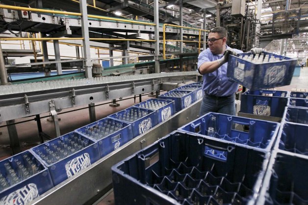 An employee carries beer boxes at a production line in a Polar brewery in Maracaibo, Venezuela July 13, 2015. Venezuela's Labor Ministry has ordered workers to lift a strike at beer maker Polar that had halted two of its breweries and restricted supplies of beer in the South American nation. Polar, the country's largest privately owned company, produces as much as 80 percent of the beer consumed in the country, which has historically been among the world's top per capita consumers of beer. Picture taken on July 13, 2015. REUTERS/Isaac Urrutia
