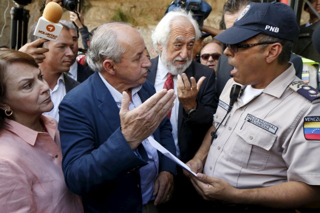 Senators from Spain Dionisio Garcia Carnero (2nd L) and Josep Maldonado (2nd R), talk to a police officer next to Mitzy de Ledezma (L), wife of arrested Caracas metropolitan mayor Antonio Ledezma, at the main gate of the detention center where opposition leader Daniel Ceballos is jailed in Caracas July 23, 2015. A group of senators from Spain are visiting Venezuela, to observe the situation of jailed opposition leaders Leopoldo Lopez, Antonio Ledezma and Daniel Ceballos, according to local media. REUTERS/Carlos Garcia Rawlins