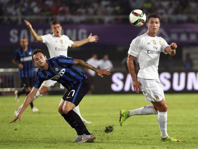 El delantero portugués del Real Madrid, Cristiano Ronaldo (d) lucha por el balón con el centrocampista croata Marcelo Brozovic (i) del Inter de Milán durante el partido amistoso disputado en Guangzhou, China hoy 27 de julio de 2015. El Real Madrid se impuso por 3-0. EFE/Xi Ya