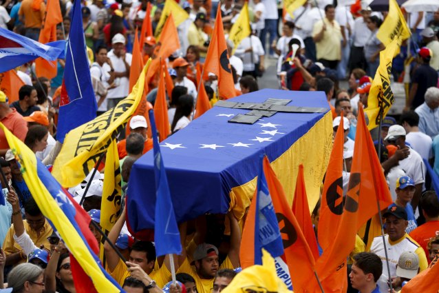 Opposition supporters hold up a mock coffin covered with a Venezuelan national flag, during a gathering to protest against the government of Venezuela's President Nicolas Maduro, and economic insecurity and shortages, in Caracas August 8, 2015. Swollen lines at supermarkets and prolonged food shortages have sparked frustration in the OPEC nation struggling with an economic crisis. REUTERS/Carlos Garcia Rawlins