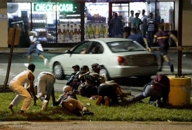 Protesters run to take cover after shots were fired in a police-officer involved shooting in Ferguson