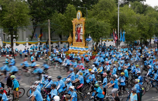 Decenas de ciclistas participan en una rodada por las calles de la capital de Tailandia por el cumpleaños número 83 de la reina Sirikit, el domingo 16 de agosto de 2015. En medio se observa un retrato de la reina. (Foto AP/Sakchai Lalit)