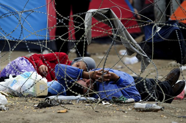 Migrants sleep at Greece's border with Macedonia, as they wait to enter Gevgelija, Macedonia, August 22, 2015. Police and soldiers deployed along Macedonia's southern border with Greece struggled on Saturday to control the numbers of refugees and migrants, many of them fleeing Middle East conflicts, seeking to reach western Europe. REUTERS/Ognen Teofilovski