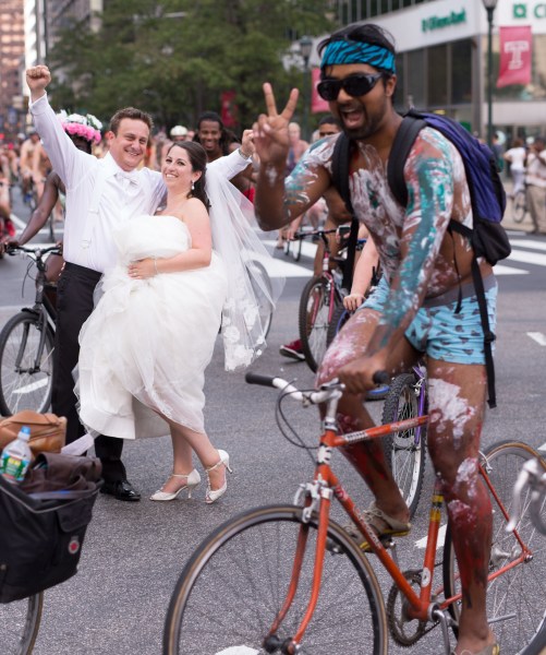 En esta imagen, tomada el 29 de agosto de 2015 photo, Ross Cohen (izquierda) y Blair Delson celebran su boda en la plaza Dilworth de Philadelphia, mientras se celebra la marcha anual de ciclistas nudistas de la ciudad. (Joseph Gidjunis/JPG Photography via AP)