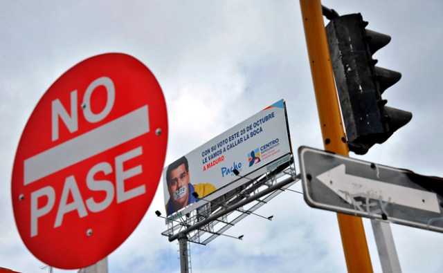 Una valla publicitaria colombiana con el rostro de Nicolás Maduro con la boca tapada, en Bogotá. AFP