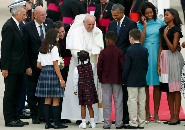 U.S. President Barack Obama and First lady Michelle Obama (2R) and daughter Sasha (R) welcome Pope Francis along with local school children at Joint Base Andrews, Maryland for the pontiff's first arrival to the United States September 22, 2015.       REUTERS/Kevin Lamarque